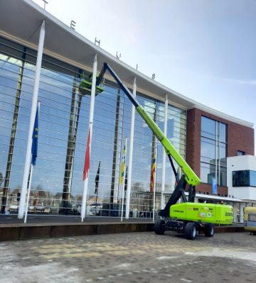 Zoomlion aerial lift in front of a modern office building.