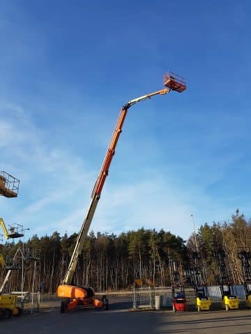 Aerial boom lift, sky, industrial area.