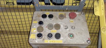 Machine control panel with buttons and markings.