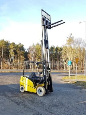 Yellow forklift in front of the forest.