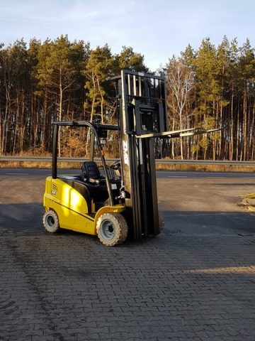 Yellow forklift in front of the forest.