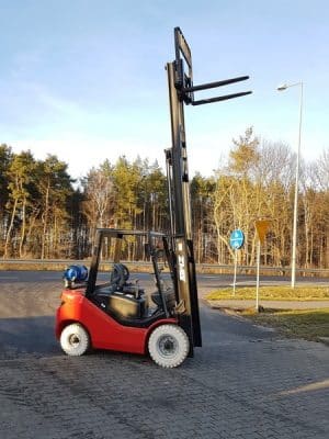 A red forklift in the parking lot.