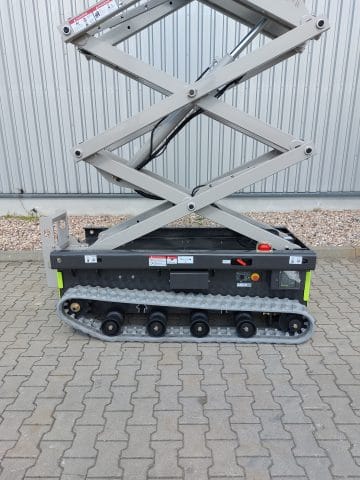 Scissor lift on tracks in front of the building.