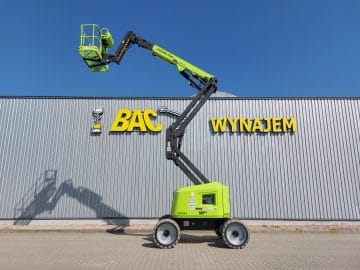 Podnośnik koszowy Zoomlion przed budynkiem z napisem "Wynajem".