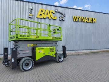 A Zoomlion scissor lift in front of a building with a rental sign.