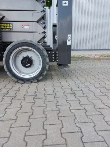 A farm trailer wheel on the pavement.