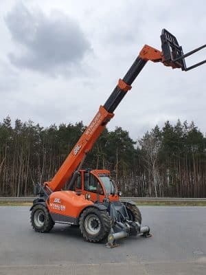 Oranger Teleskoplader an einem Waldweg