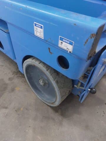 Blue pallet truck, close-up of the wheel.