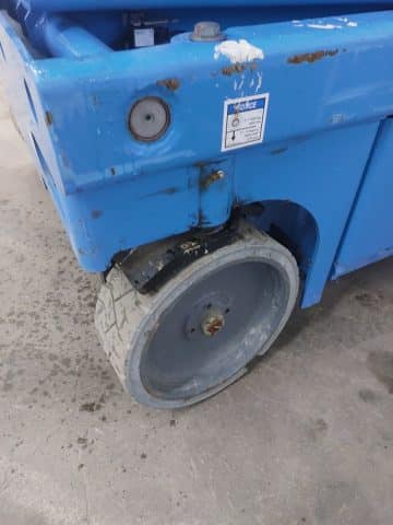 Destroyed wheel of blue industrial container.