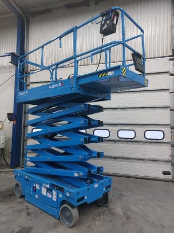 A blue lift truck on an industrial background.
