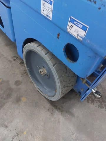 Plochá pneumatika vysokozdvižného vozíka na pracovisku.