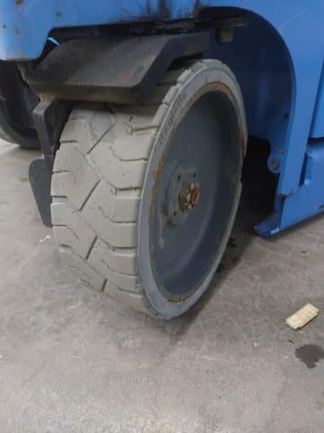 The wheel of a forklift in an industrial hall.