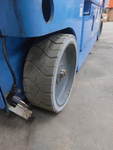 An undamaged forklift wheel on the shop floor.