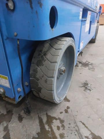 Blue waste container with a damaged wheel.