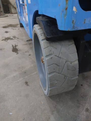A worn forklift tire on concrete.