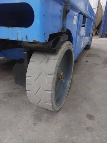 The solid wheel of an industrial vehicle on the shop floor.
