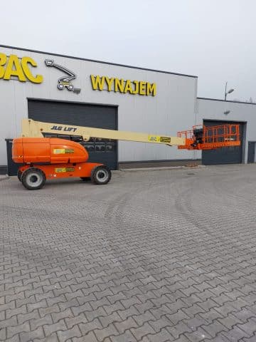 JLG scissor lift in front of building with sign "RENTAL