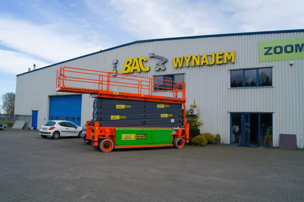 Scissor lift in front of the hall with the sign "Renting