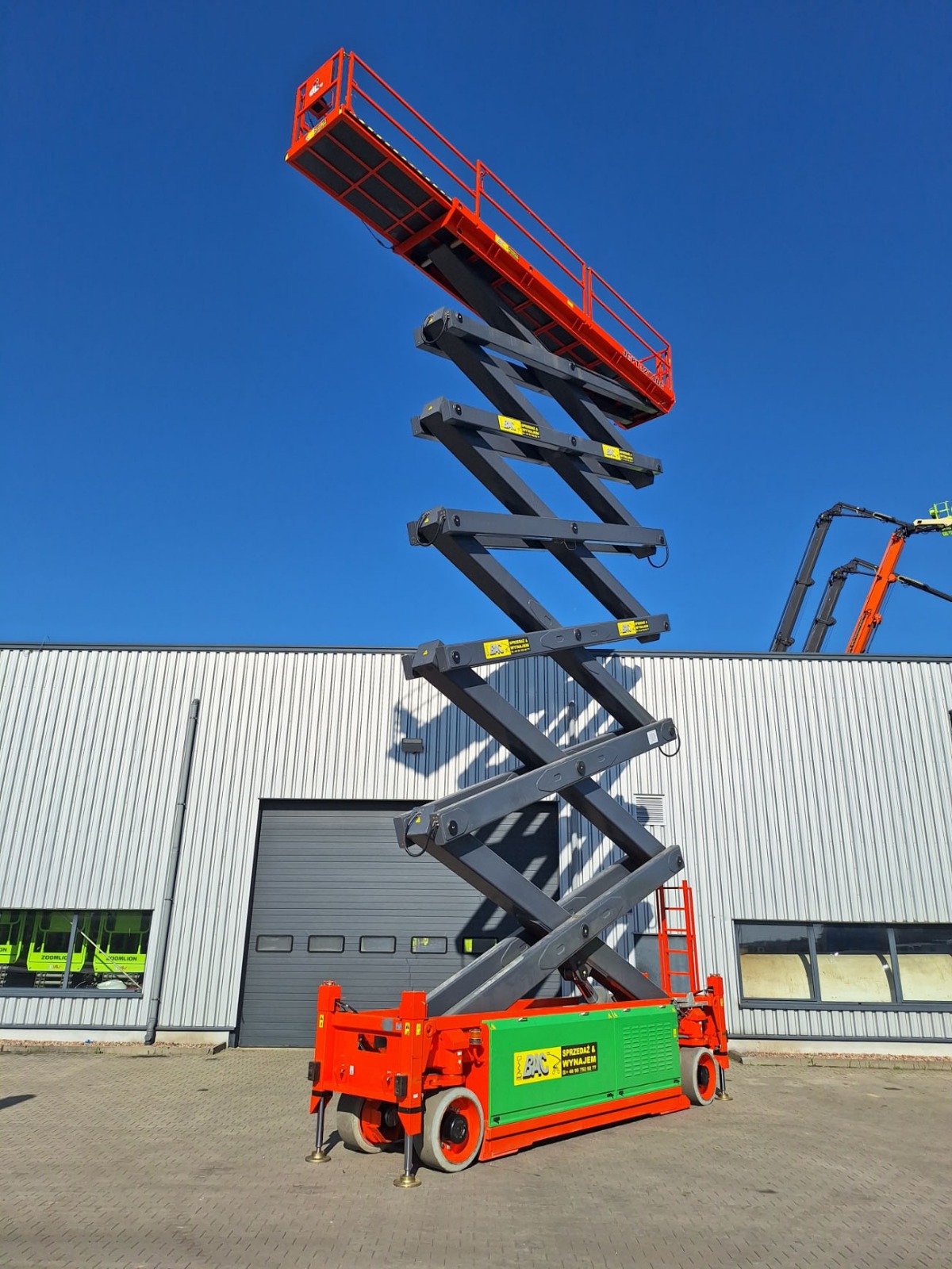 Podnośnik nożycowy Dingli JCPT 3214 DC w trakcie pracy – elektryczny model z maksymalną wysokością roboczą 32 metry, przeznaczony do zadań wymagających dużego zasięgu pionowego, dostępny w ofercie wynajmu Bac Polska.