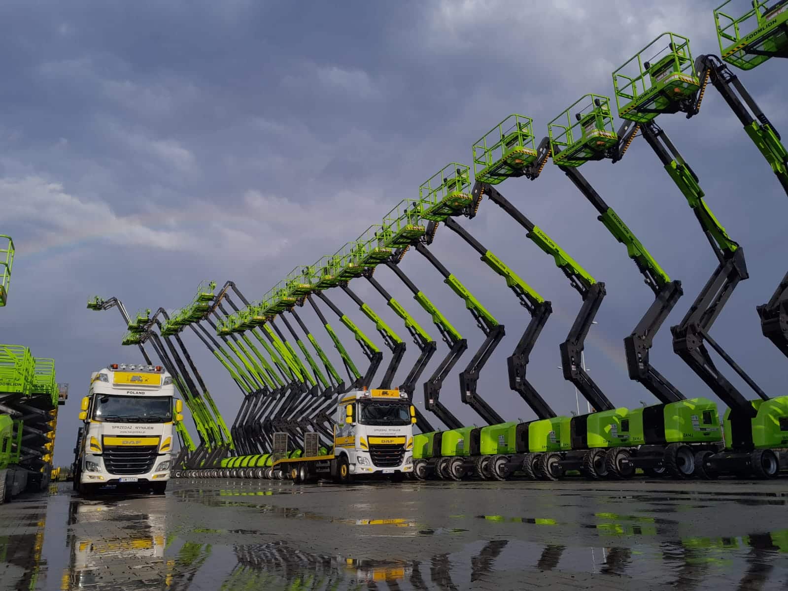 Hubarbeitsbühnen und Lkw auf nassem Asphalt.